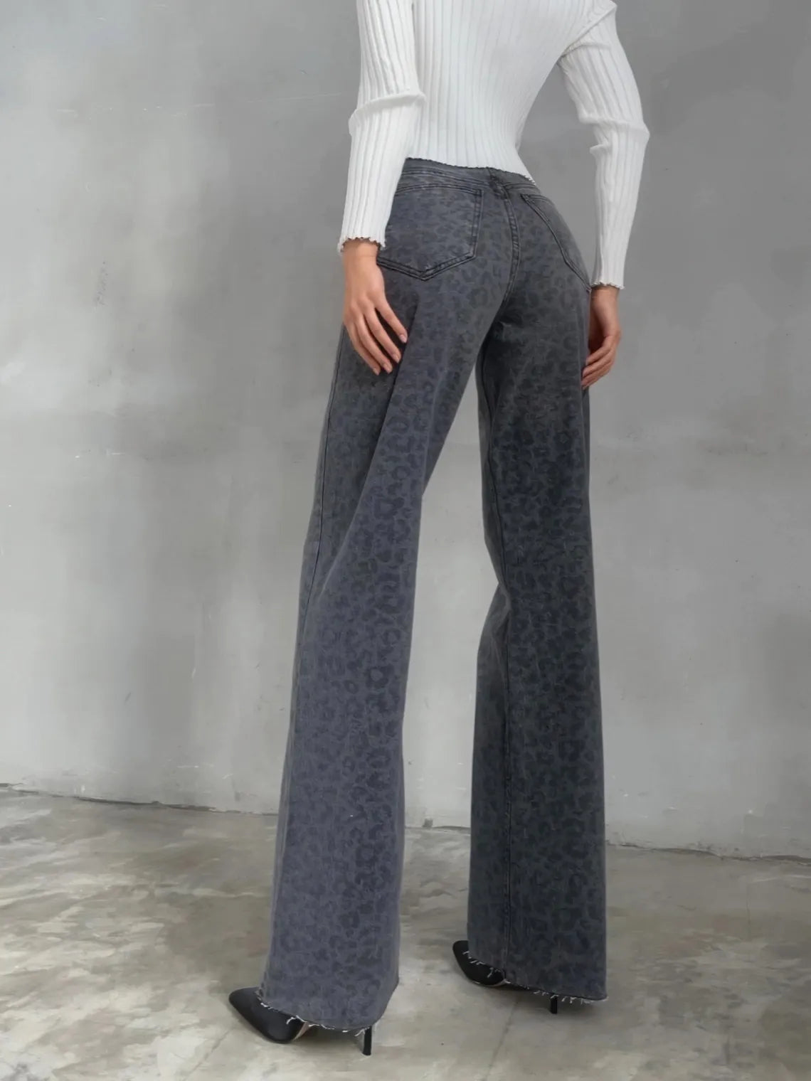 Person wearing gray patterned pants and a white top against a gray background. #Color_DimGray