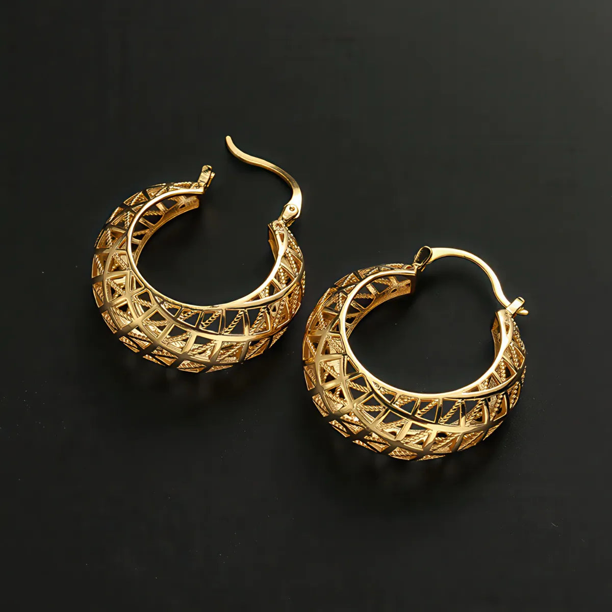 Gold hoop earrings with intricate designs on a black background. #Style_B