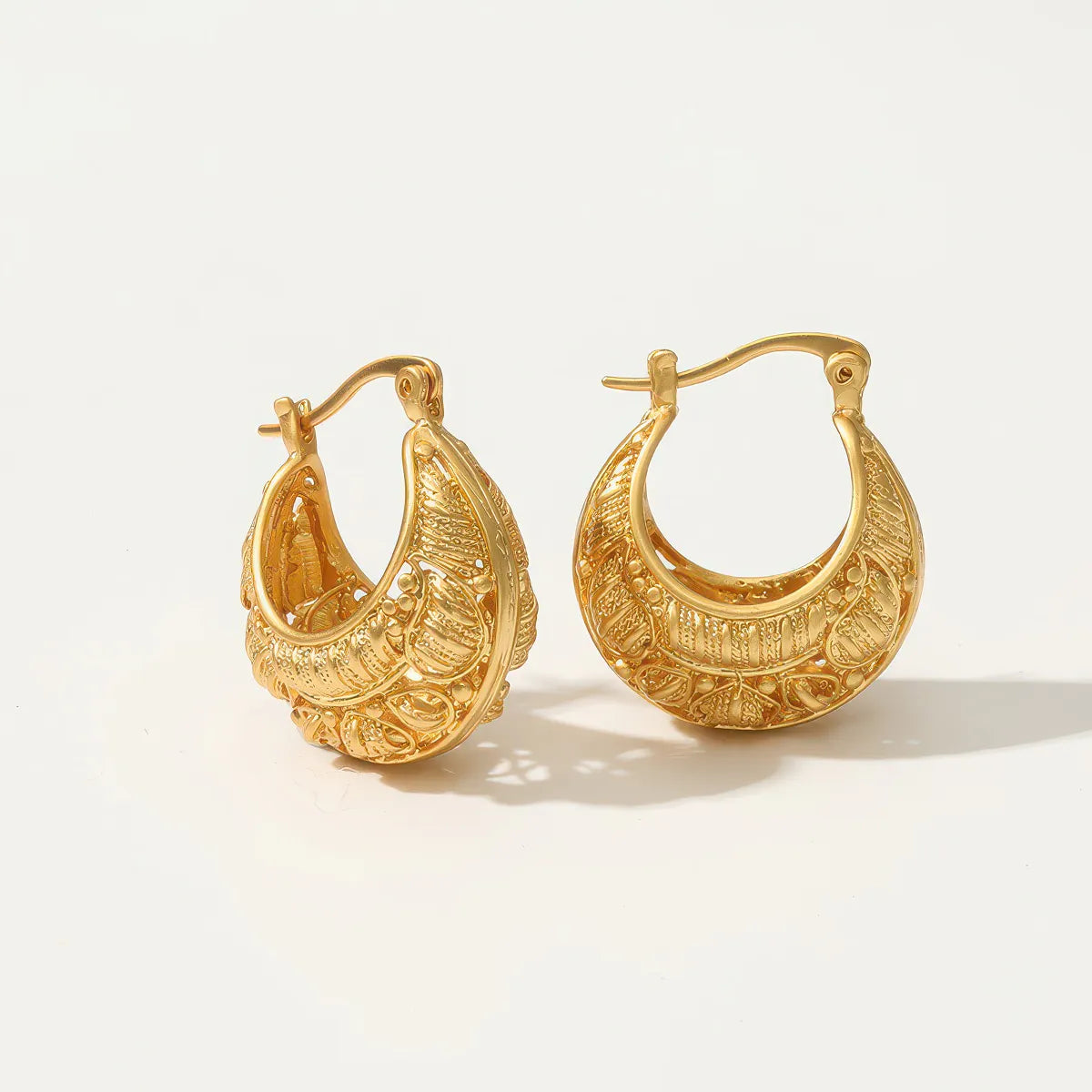 Pair of gold hoop earrings on a light background. #Style_C
