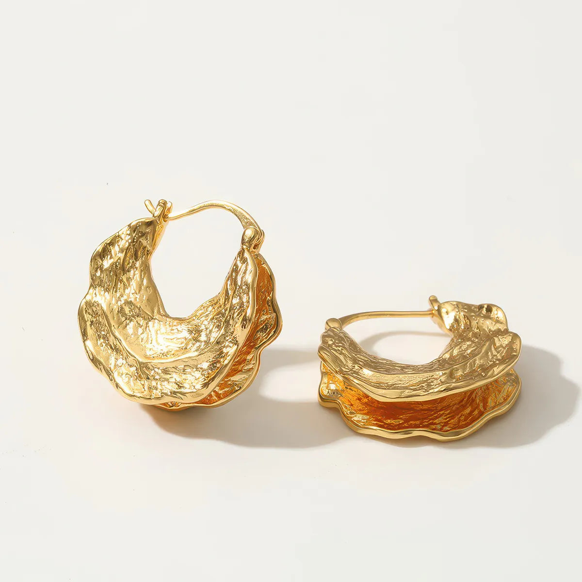 Pair of gold hoop earrings on a light background. #Style_D