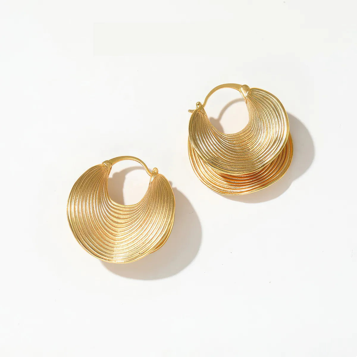 Pair of gold hoop earrings on a white background. #Style_E