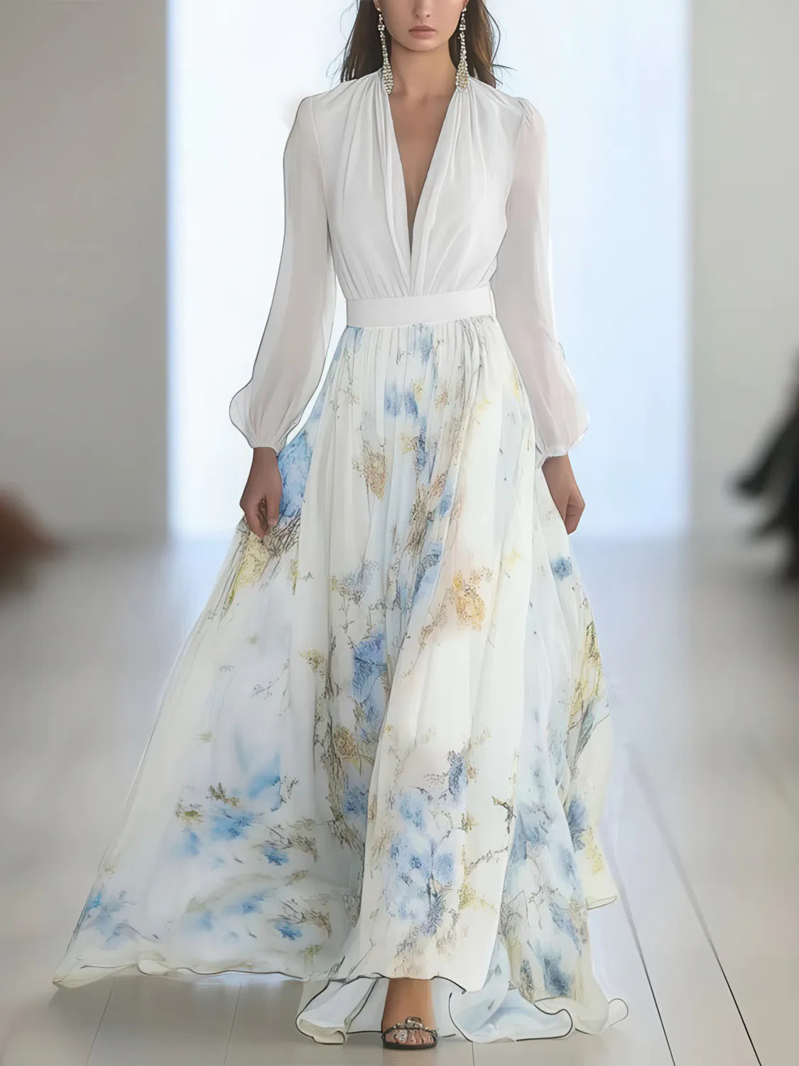 Woman wearing a white blouse with a long floral skirt on a plain background