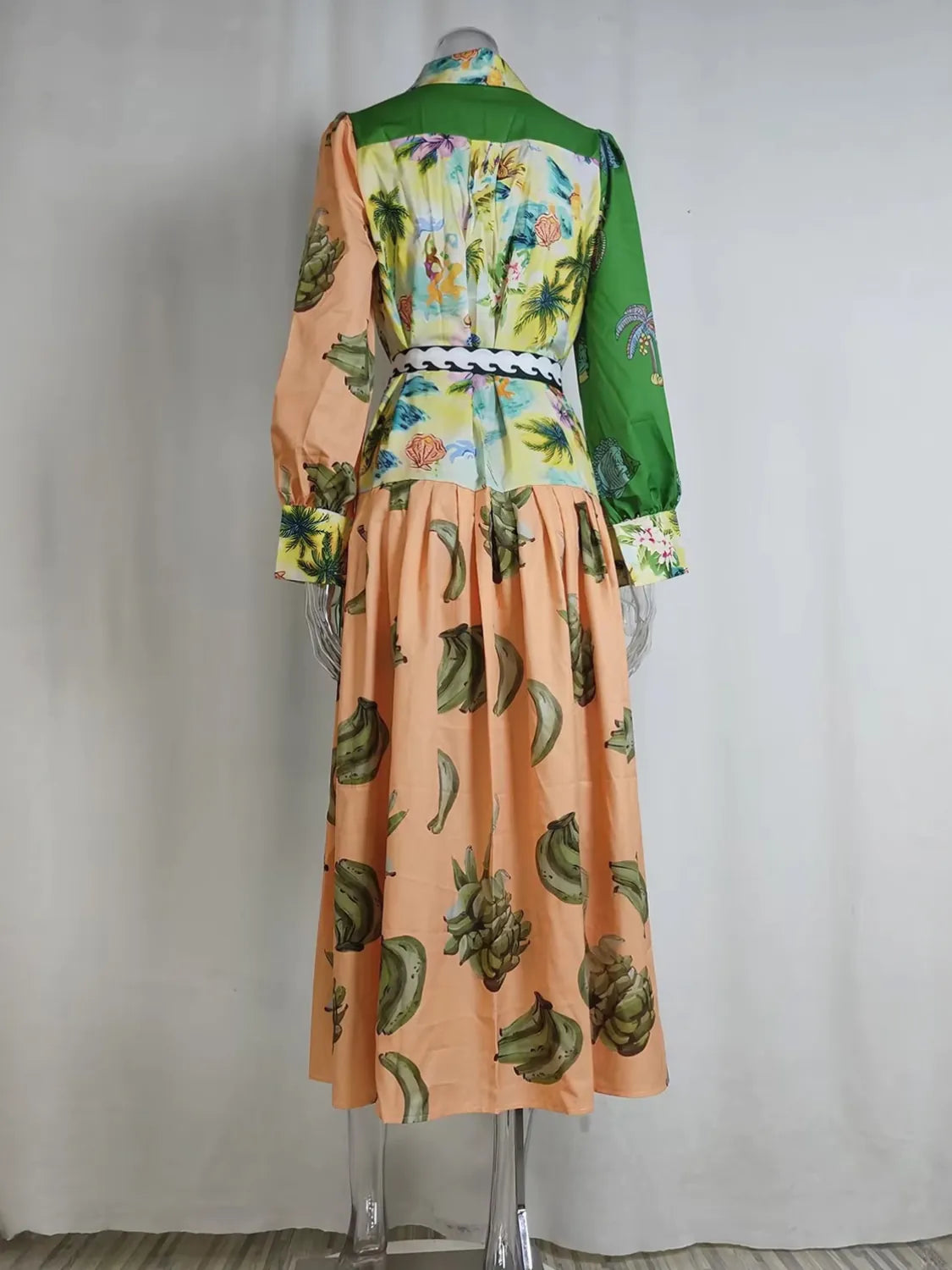 Mannequin wearing a colorful dress with a green top and peach skirt on a plain background. #Color_RosyBrown