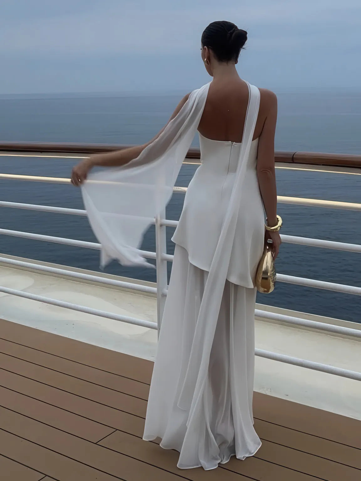 Woman in a white dress standing on a cruise ship deck with ocean view. #Color_White