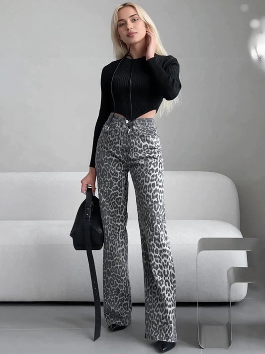 Woman wearing leopard print pants and a black top in a minimalistic setting. #Color_Gray