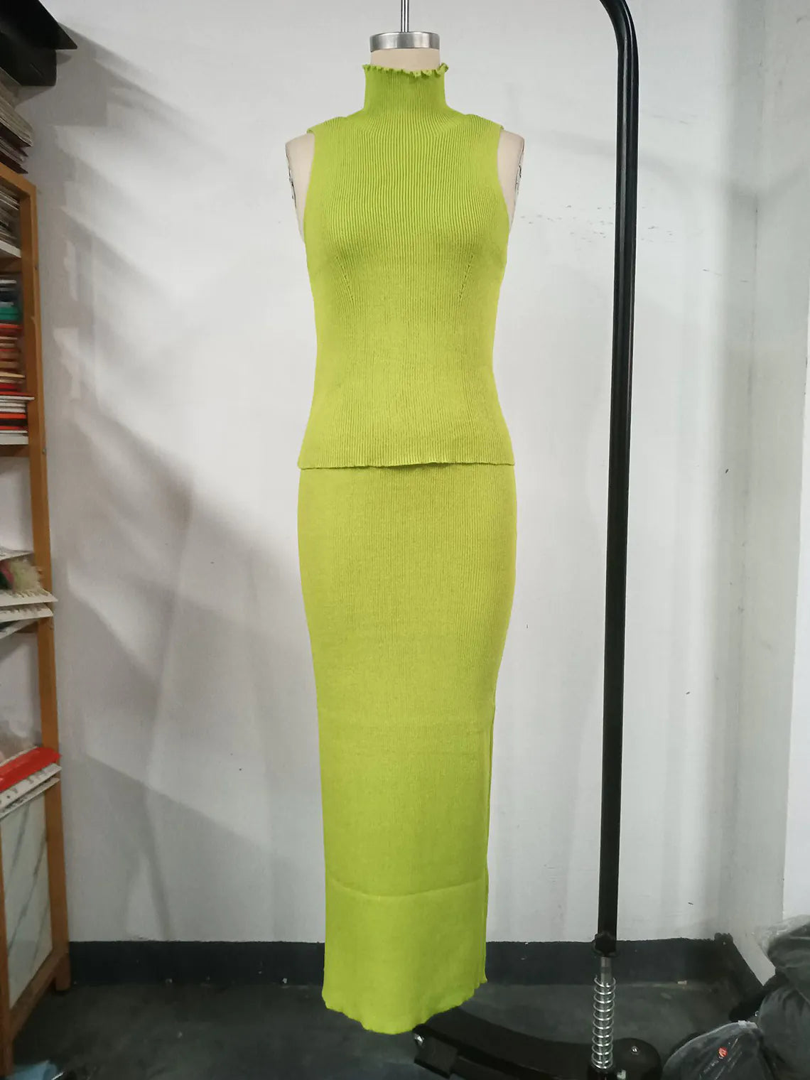 Green dress on a mannequin against a white wall. #Color_Green