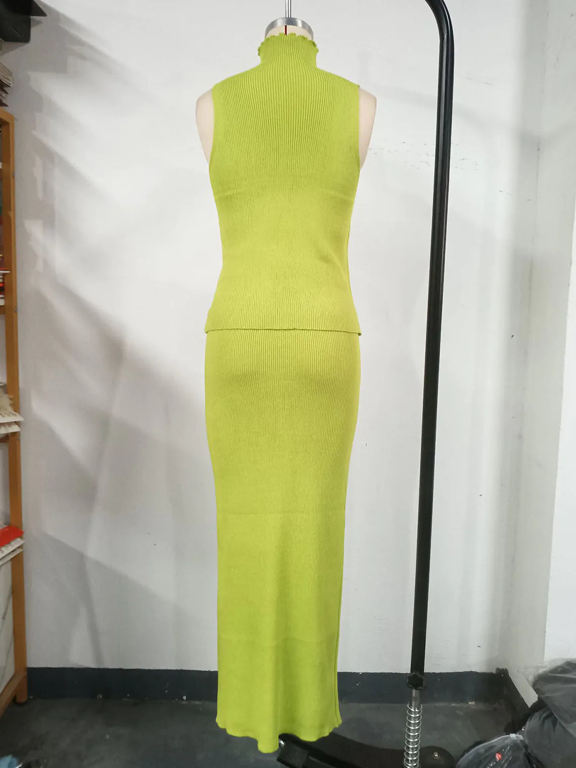 Green dress on a mannequin against a white wall. #Color_Green