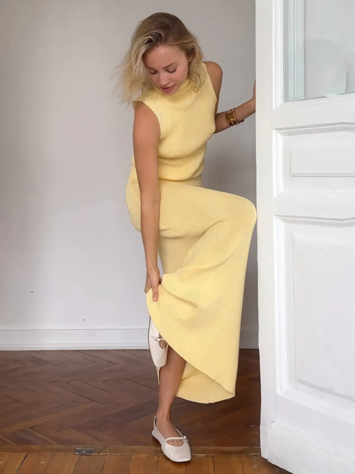 Woman in a yellow dress standing in a doorway. #Color_Yellow